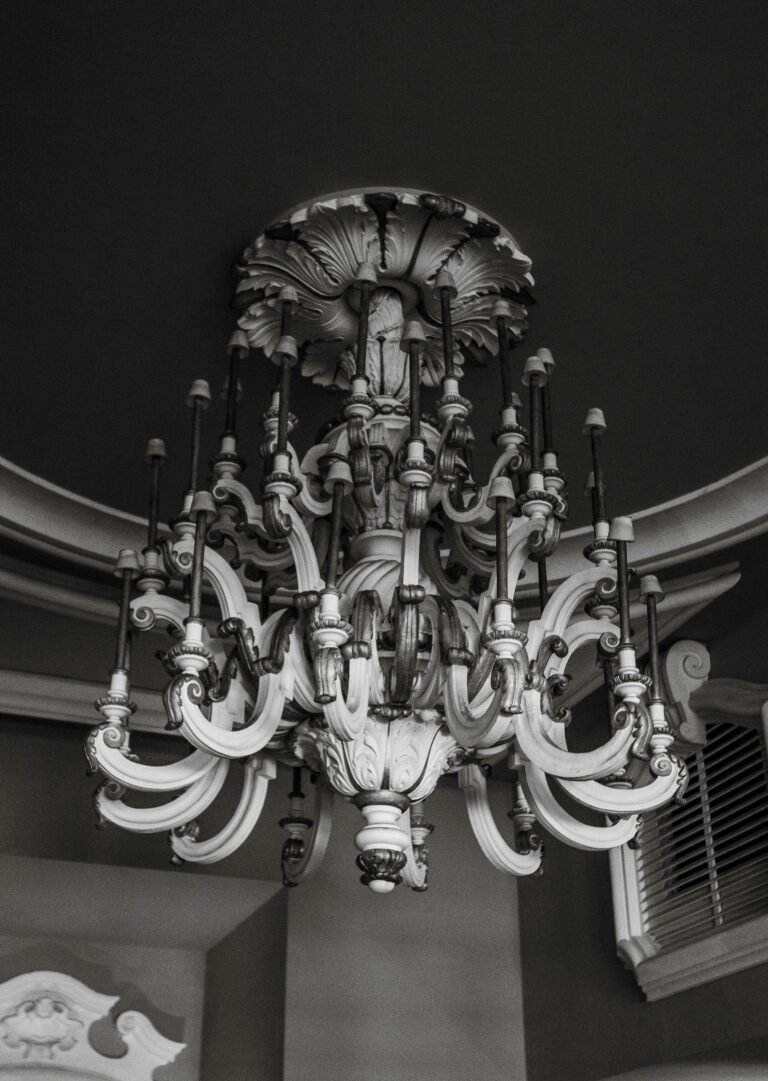 A detailed black and white photo of an ornate vintage chandelier indoors.