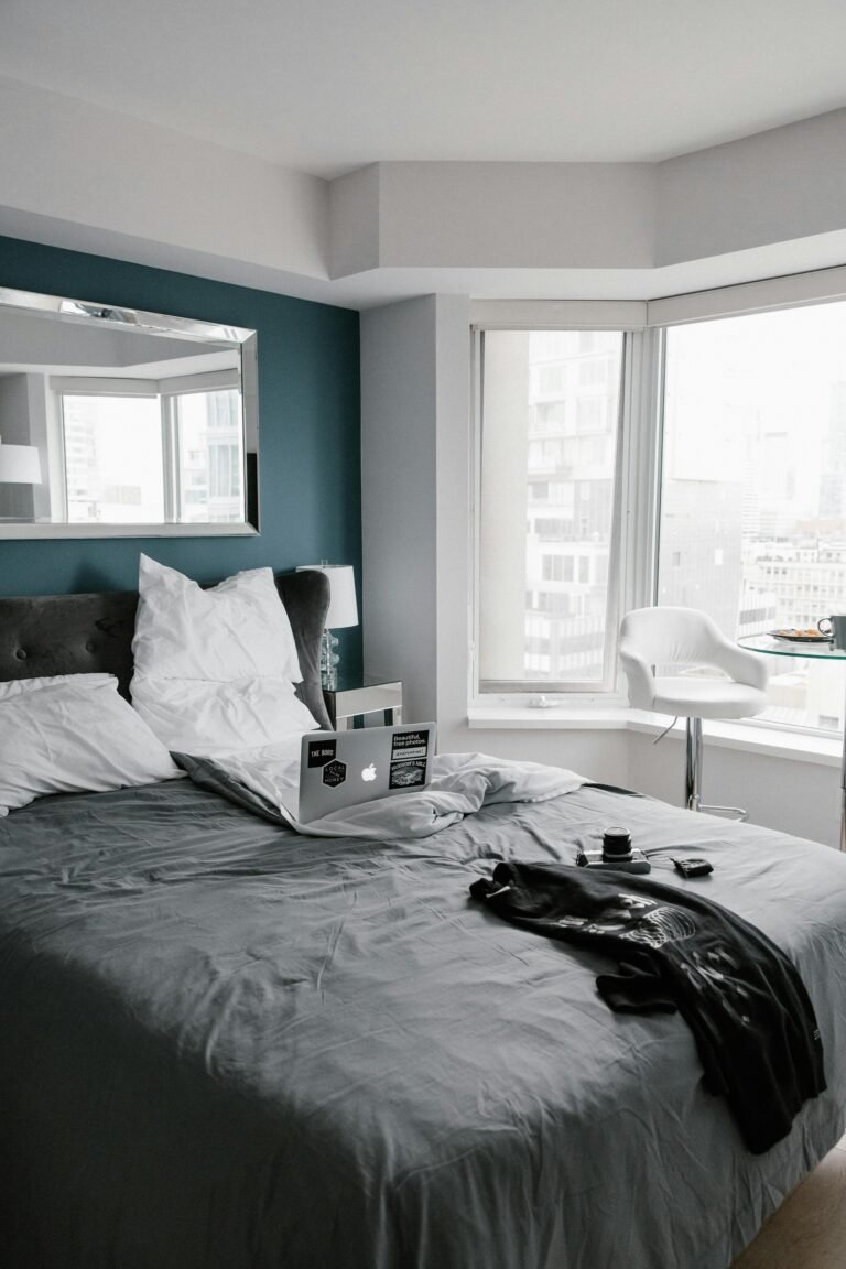 Comfortable bedroom in Toronto with a city view, featuring a laptop and modern decor.