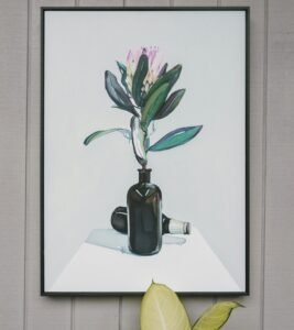 Stylish wall art featuring a botanical painting above a live houseplant.
